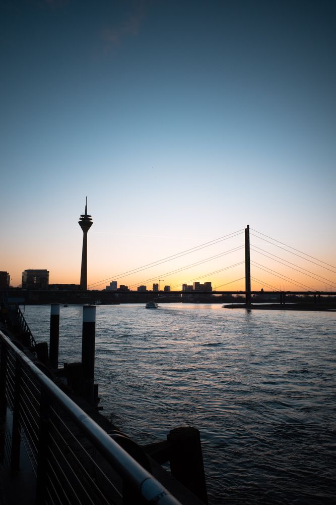 Düsseldorfer Rheinturm und Rheinbrücke bei Sonnenuntergang